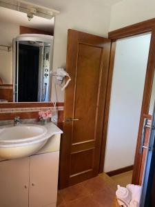a bathroom with a sink and a wooden door at Alojamiento Finca La Campa in Mareo de Abajo +21 photos