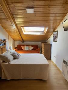 a bedroom with a large bed and a skylight at Alojamiento Finca La Campa in Mareo de Abajo