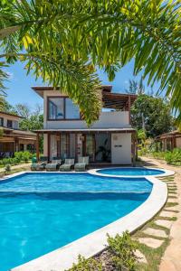 a house with a swimming pool in front of a house at Casa em Barra Grande - Península de Maraú in Barra Grande