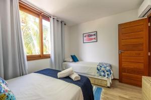 a bedroom with two beds and a window at Casa em Barra Grande - Península de Maraú in Barra Grande +35 photos