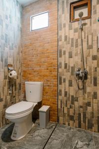 a bathroom with a toilet and a brick wall at Diamond Beach Resort in Ko Samed