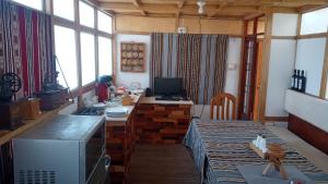 a room with a table and a desk with a computer at Inti Panqara in Juliaca