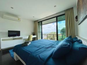 a bedroom with a large blue bed and a television at Patong - The Unity Seaview & Mountain Residence in Patong Beach +159 photos