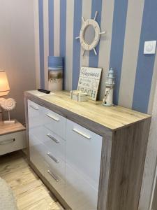 a dresser in a bedroom with a blue and white wall at Apartament Dani-Apart in Gdańsk