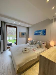 a bedroom with a large bed and a large window at Apartament Dani-Apart in Gdańsk