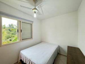 a bedroom with a bed and a window at Apto a 300 metros da Praia da Riviera de São Lourenço in Bertioga