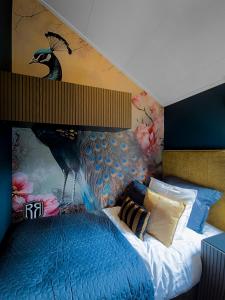 a bedroom with a large blue bed with a peacock mural at Royal Resort Cosy Cabin met Hottub in Haarle