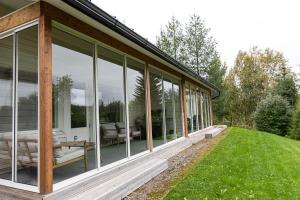 a house with large glass windows on the side of it at Cozy Aurora Chalet with Sauna By BookLapland in Rovaniemi