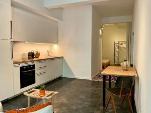 a kitchen with white cabinets and a table with chairs at Studio Richard in Antwerp