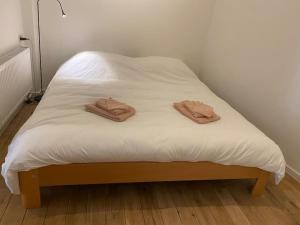 two brown towels sitting on a white bed at Studio Richard in Antwerp