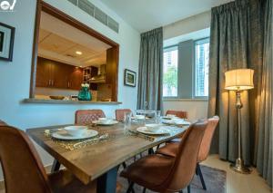 a dining room with a wooden table and chairs at 2BR Luxury Suite with a Garden View in Dubai