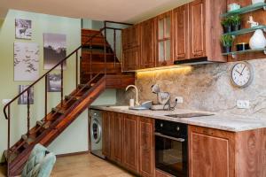 a kitchen with wooden cabinets and a staircase at Alpine Retreat Maisonette in Bansko