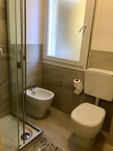 Un baño con inodoro, lavabo y ducha. en Condominio Torino - Petit 22, en Caorle 8 fotos más