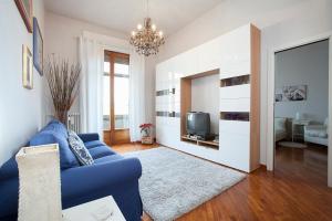 a living room with a blue couch and a tv at La Gare Apartment in Florence