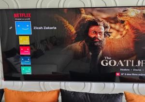 a television with a movie on the screen at Villa de Luxe à Dar Bouazza Piscine Privée Fibre 100 Mbps Netflix et YouTube Premium in Casablanca