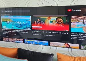 a wall with a large screen behind a couch at Villa de Luxe à Dar Bouazza Piscine Privée Fibre 100 Mbps Netflix et YouTube Premium in Casablanca