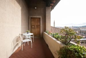 a balcony with a table and chairs on a building at La Gare Apartment in Florence