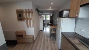 a small kitchen with a refrigerator and a table at Apartament "Rodzinny zakątek" in Duszniki Zdrój +11 photos