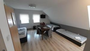 a room with two beds and a table and chairs at Apartament "Rodzinny zakątek" in Duszniki Zdrój