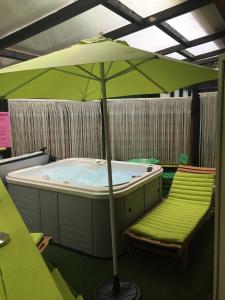 a hot tub with two chairs and an umbrella at Appartement SAB in Issel +3 photos