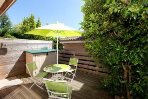 a patio with a table and chairs and an umbrella at Appartement SAB in Issel
