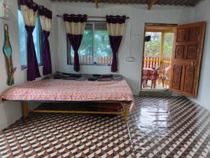 een slaapkamer met een bed en een raam met gordijnen bij Omkar Homestay Adgaon Beach Sea View Next to Diveagar in Adgaon