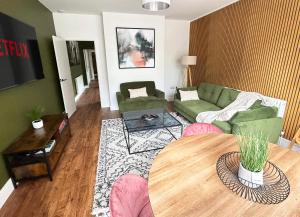 a living room with a green couch and a table at 1 Bed & 1 Sofa Bed Alpine Style Ground Floor Apartment in Yeovil