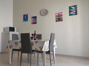 a dining room table with chairs and a clock on the wall at Storm Sonic House in Palo del Colle