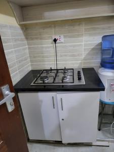 a stove top in a small kitchen with a toilet at G&G Homes Pioneer 1 bedroom in Eldoret