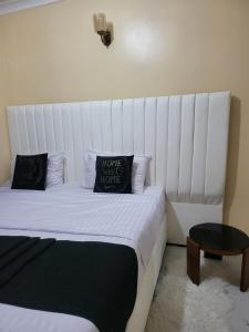 a bedroom with a bed with a white headboard at G&G Homes Pioneer 1 bedroom in Eldoret