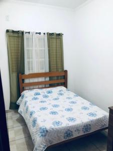 una camera da letto con un letto con un piumone blu e bianco di Chácara Estancia JH a Presidente Epitácio Altre 32 foto