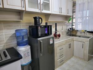 a kitchen with a refrigerator with a coffee maker on it at G&G Homes Pioneer 1 bedroom in Eldoret