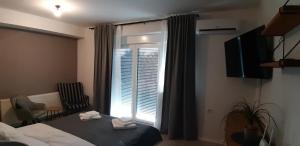 a bedroom with a bed and a window with a blind at Sunny Residence self check-in in Virovitica