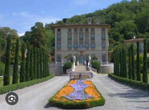 a building with a flower garden in front of it at Trescore Balneario Bus 500m 8Posti Wi-Fi Check in 24h in Trescore Balneario