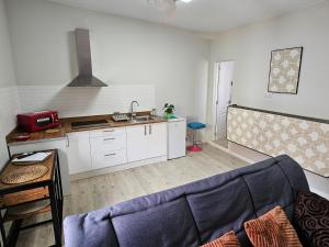 a living room with a couch and a kitchen at Apartamentos GARAKOTA in Telde