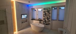 a white bathroom with a tub and a window at Baltivia ADULTS ONLY in Świnoujście