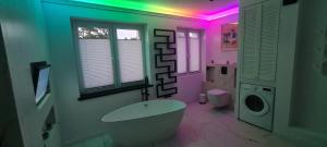 a bathroom with a tub and a pink ceiling at Baltivia ADULTS ONLY in Świnoujście +5 photos