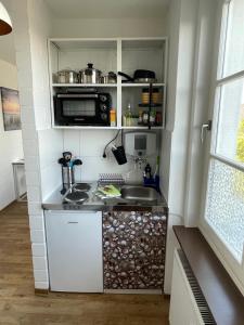 a small kitchen with a sink and a microwave at Hunteliebe in Oldenburg
