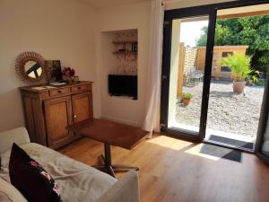 a living room with a couch and a table and a television at Maison Juliette in Loupiac-de-Cadillac