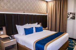 a hotel room with a large bed with blue pillows at Taba Al Salam in Medina +34 photos