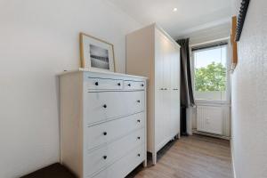 a bedroom with a white dresser and a window at Ferienappartement Holm Ostsee in Brasilien