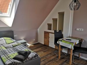 a bedroom with a bed and a desk and a table at Hainich in Oberdorla
