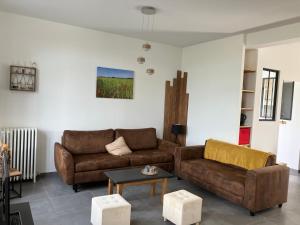 a living room with two brown couches and a table at La Brossière in Landouzy-la-Cour +23 photos