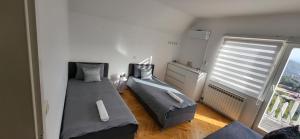 a bedroom with two beds and a large window at Villa Sunny side Sarajevo in Sarajevo