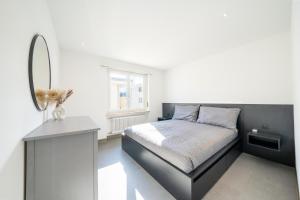 Schlafzimmer mit einem Bett mit einem Spiegel und einem Tisch in der Unterkunft Renovated Lake View Apt with AirCon in Minusio