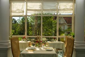a table with chairs and a large window at Résidence de Tourisme Vacances Bleues Villa Regina in Arcachon