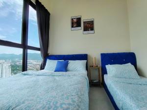 una camera da letto con due letti e una grande finestra di world premium apartment 3BR pool sea view netflix 14pax a27 a Jelutong