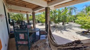 a porch with a hammock and a table and chairs at Eco-Hotel Chevere Beach in Puebloviejo