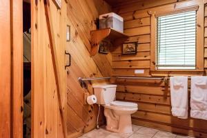 a bathroom with a toilet in a log cabin at Creekside Cabin Hot Tub Near Wineries Sleeps 4 in Dahlonega +41 photos