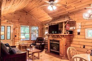a living room with a fireplace in a log cabin at Creekside Cabin Hot Tub Near Wineries Sleeps 4 in Dahlonega